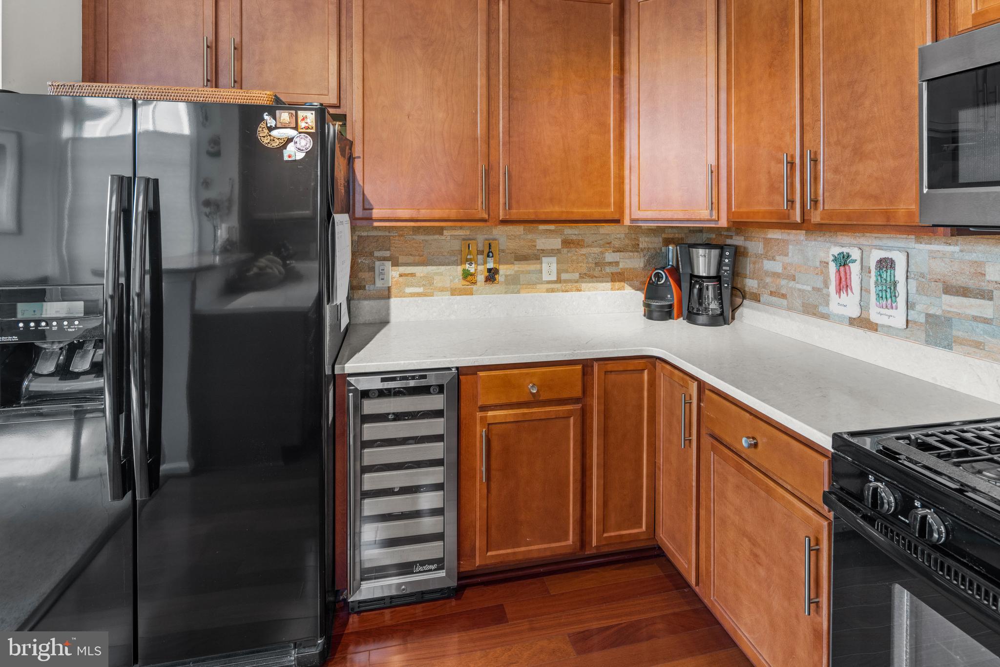 227 Timberlake Drive Ewing, NJ 08618 - Photo 9 of 21 a kitchen with stainless steel appliances granite countertop a refrigerator a stove and a sink with wooden cabinets