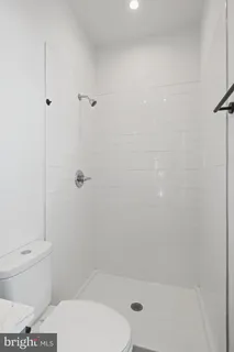 a bathroom with a granite countertop toilet sink and mirror