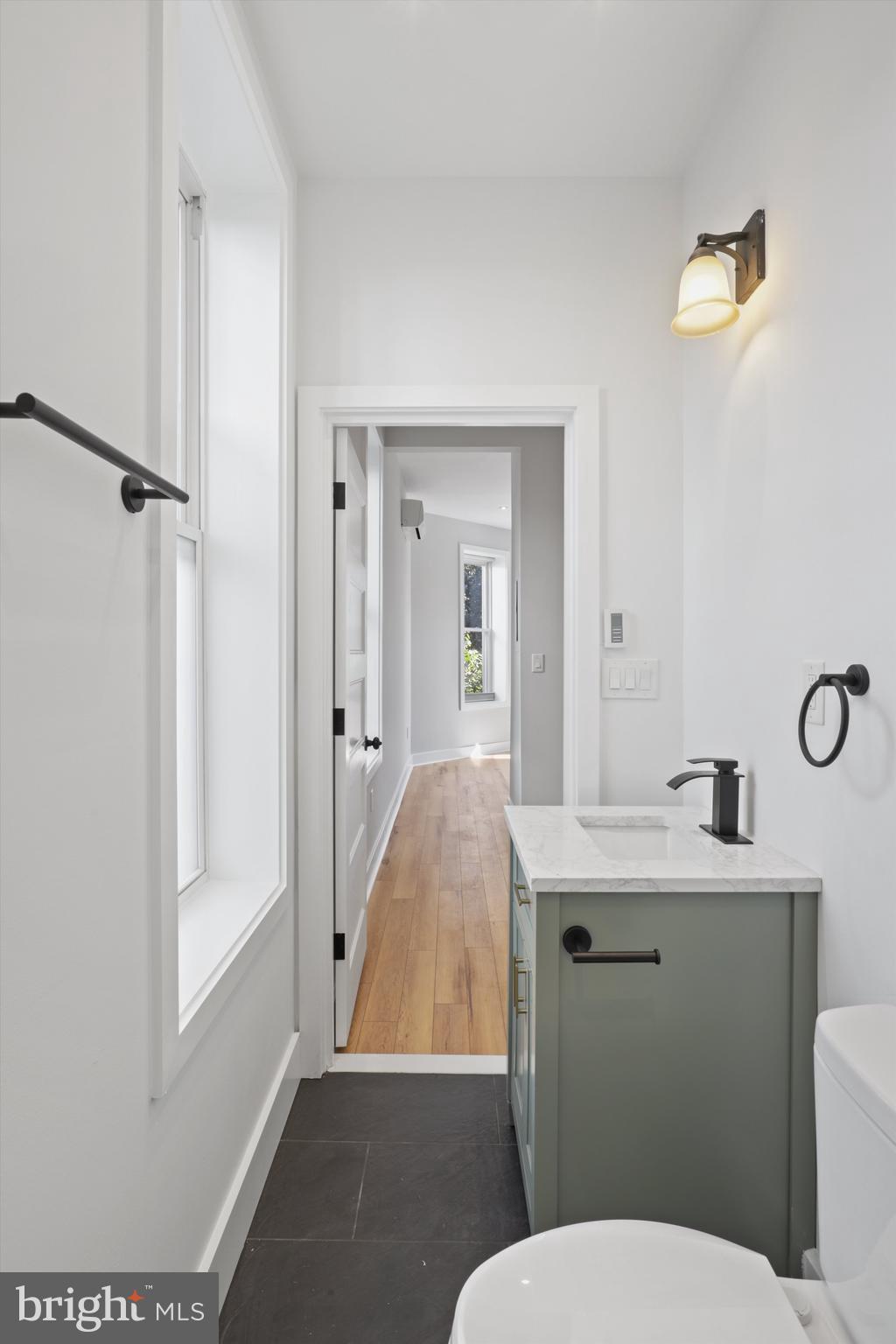 3504 13th Street Northwest, Unit 12 Washington, DC 20010 - Photo 14 of 24 a bathroom with a granite countertop toilet sink and mirror