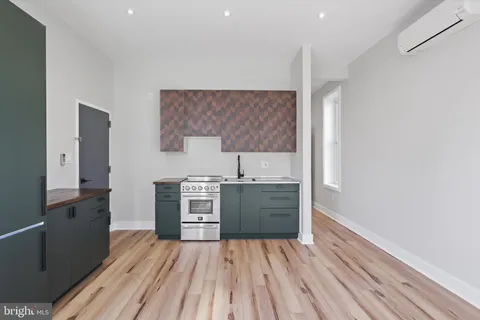 a kitchen with cabinets wooden floor and stainless steel appliances