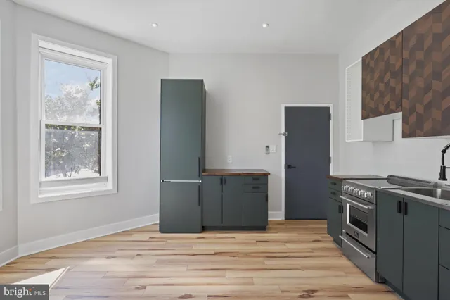 a kitchen with stainless steel appliances granite countertop a refrigerator stove and sink