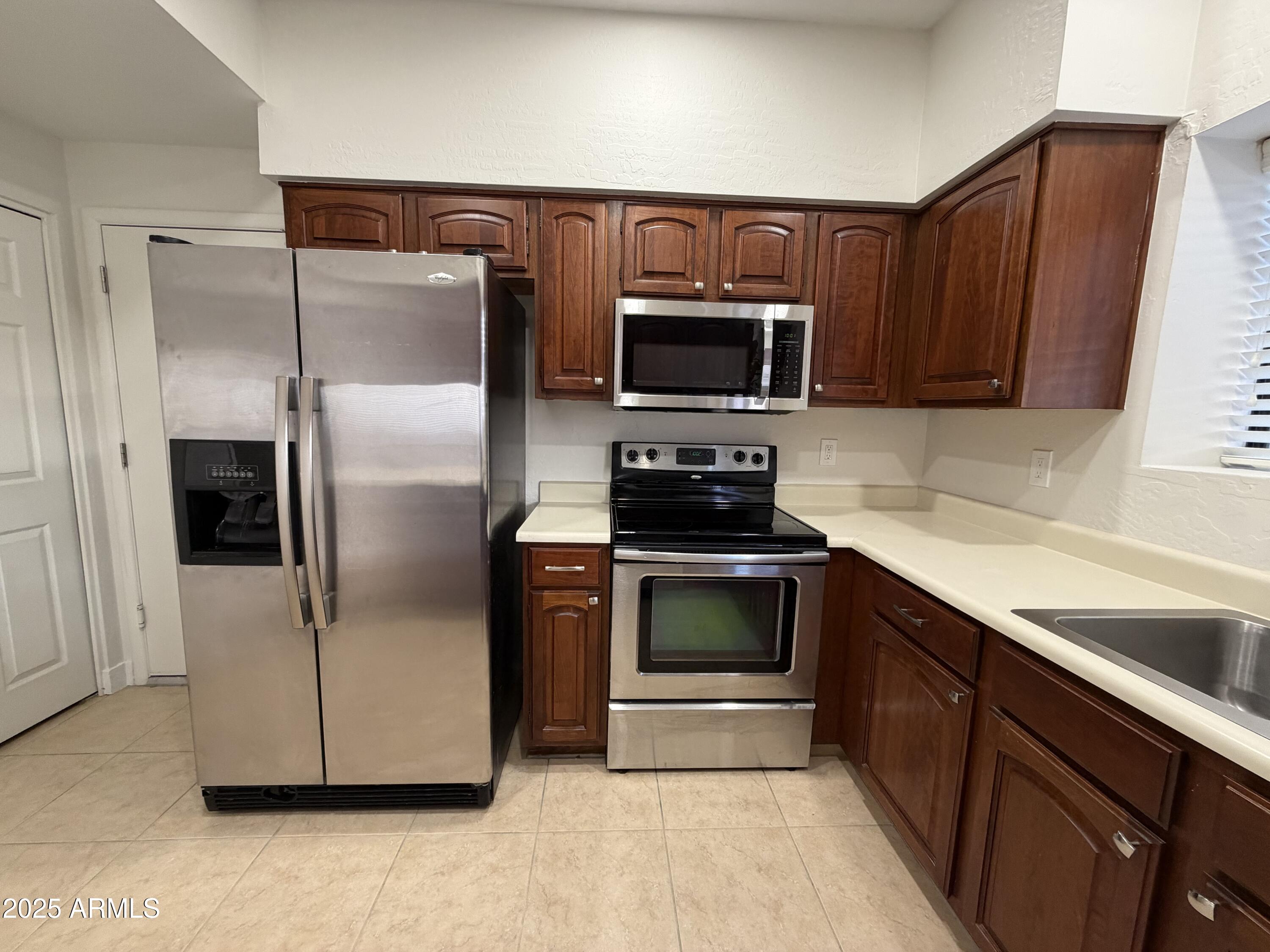 4434 East Annette Drive Phoenix, AZ 85032 - Photo 11 of 27 a kitchen with granite countertop a refrigerator and a sink