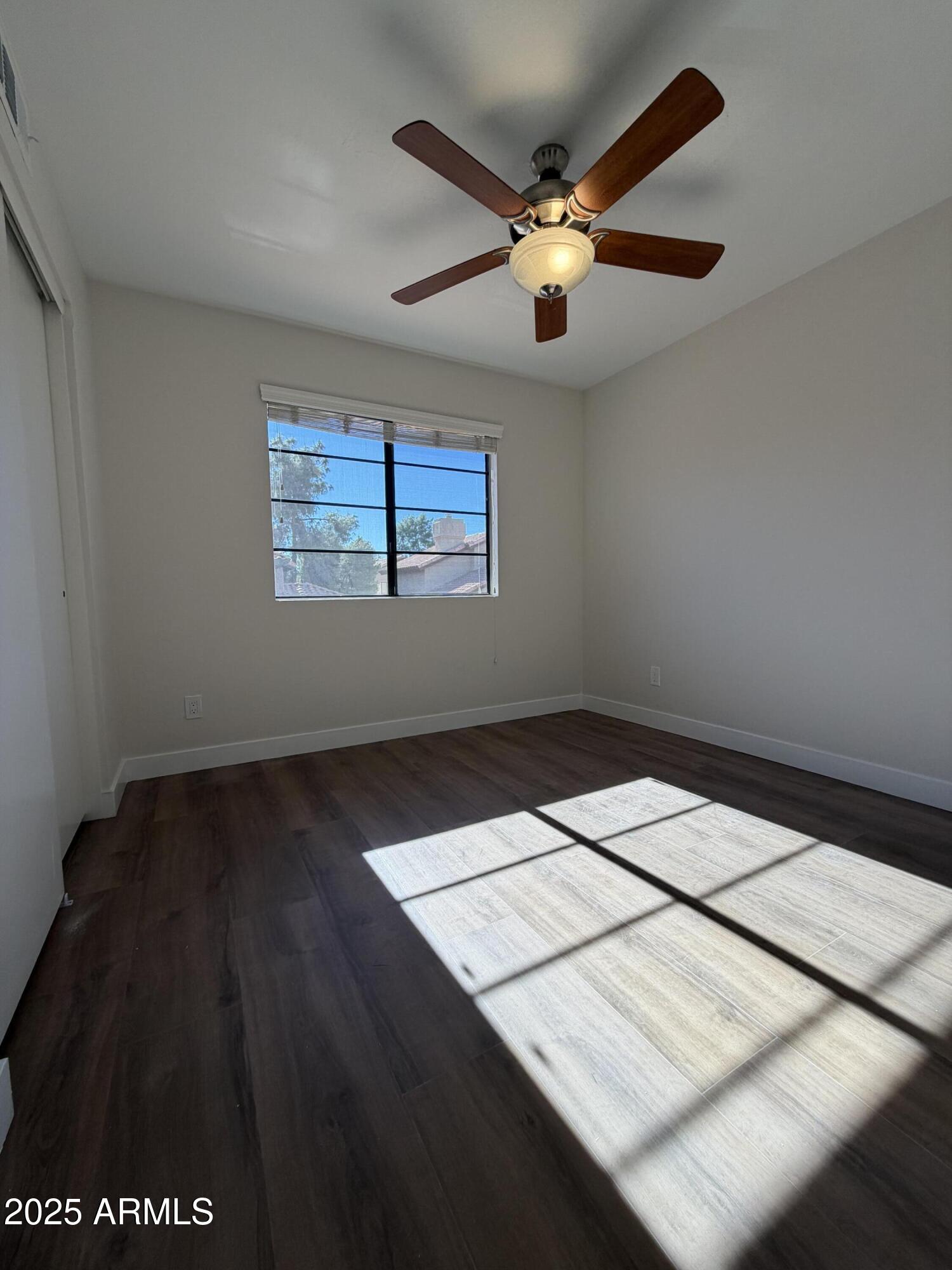 4434 East Annette Drive Phoenix, AZ 85032 - Photo 23 of 27 an empty room with wooden floor and windows