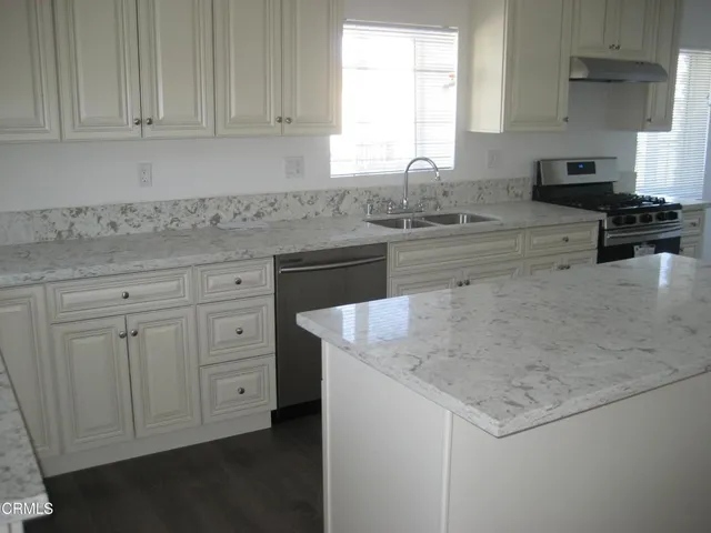 a kitchen with granite countertop white cabinets and a sink