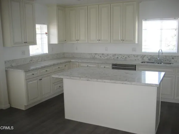 a kitchen with granite countertop cabinets sink and window