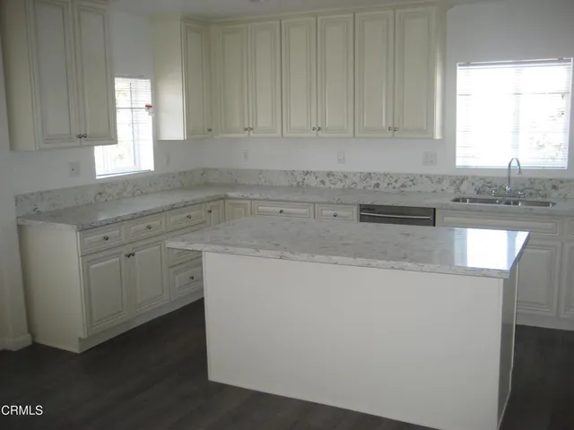 a kitchen with granite countertop cabinets sink and window