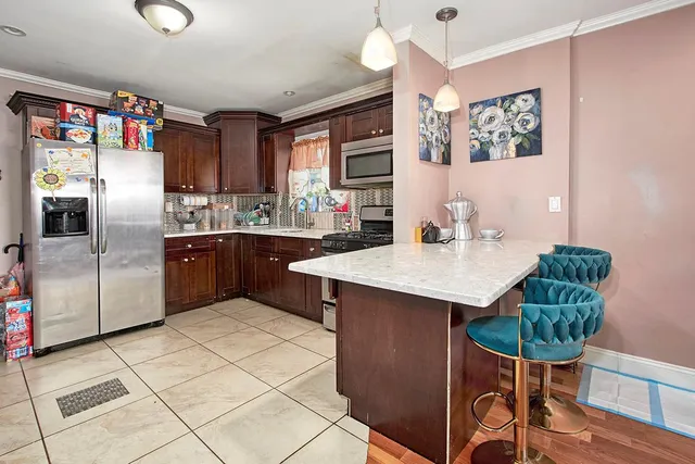 a kitchen with stainless steel appliances a table chairs and a refrigerator