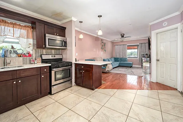 a view of a hallway with wooden floor and a potted plant