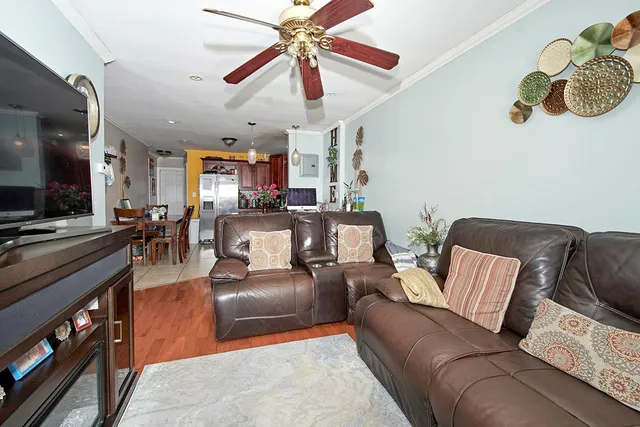 a living room with furniture kitchen view and a flat screen tv