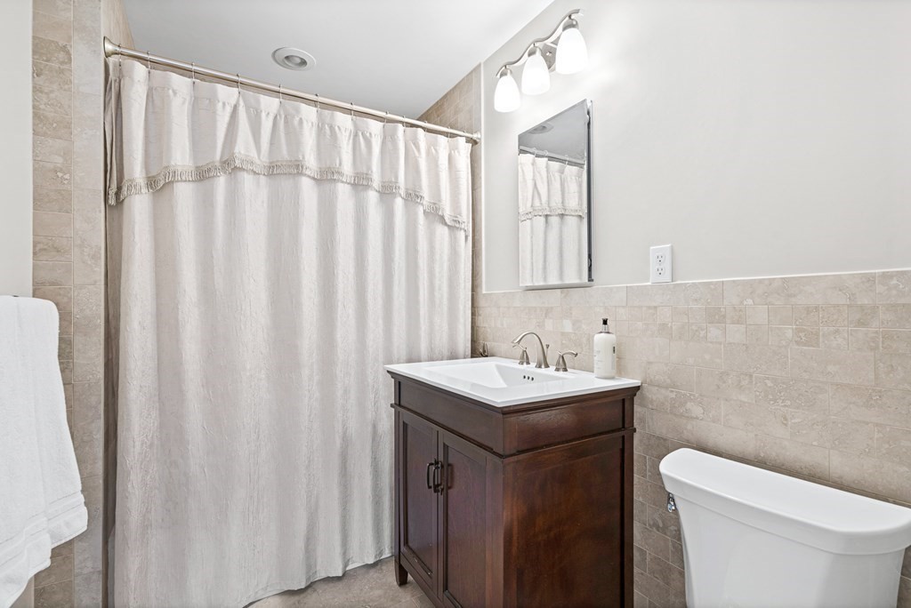 9 Laird Road Medford, MA 02155 - Photo 30 of 41 a bathroom with a sink a toilet and a mirror