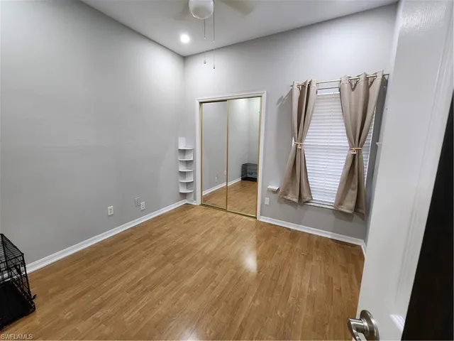 a view of empty room with wooden floor