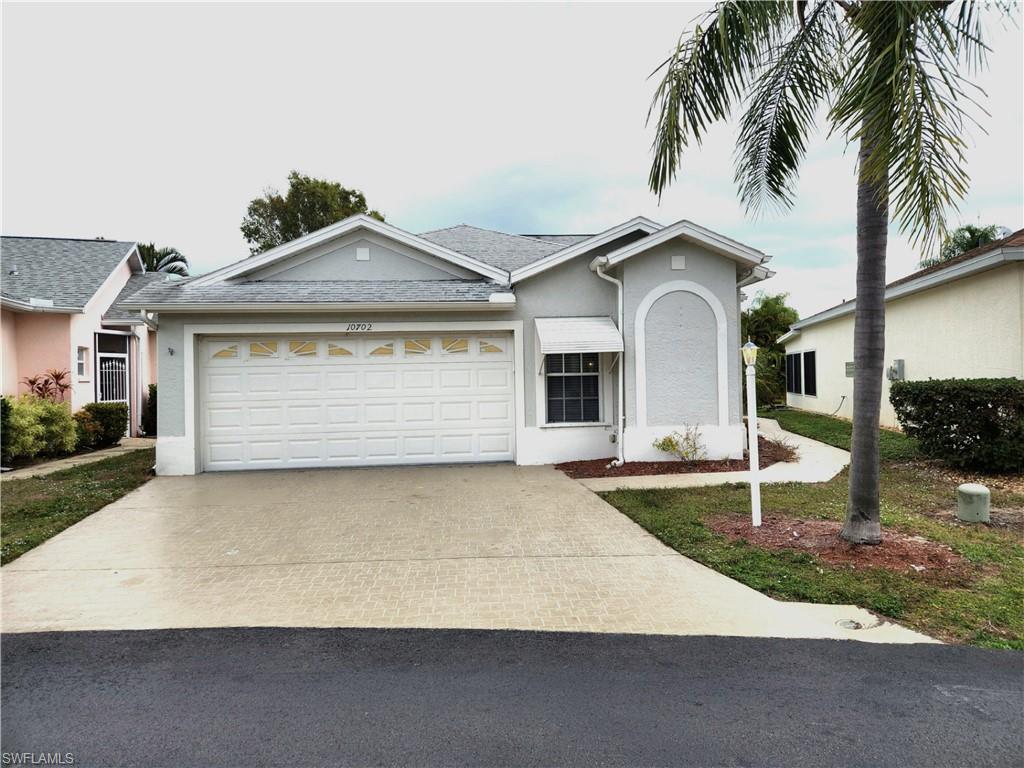 10702 Rio Mar Circle Estero, FL 33928 - Photo 2 of 21 a front view of a house with a yard and garage