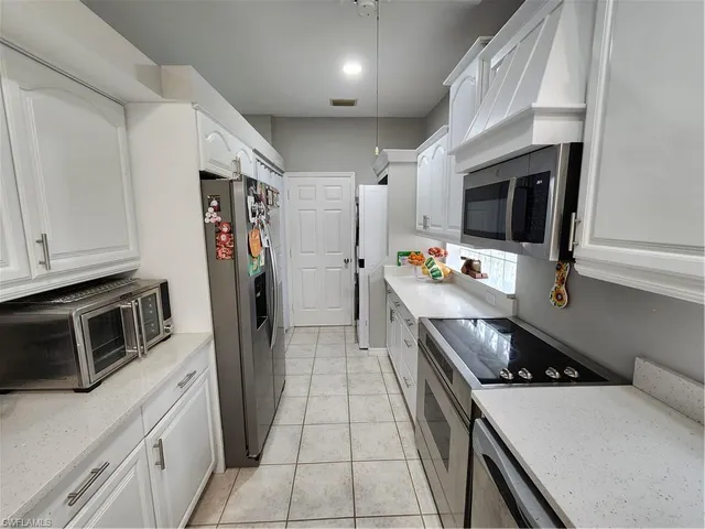 a kitchen with stainless steel appliances a stove microwave and refrigerator