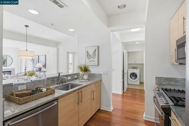 a kitchen with stainless steel appliances granite countertop a sink stove and wooden floor