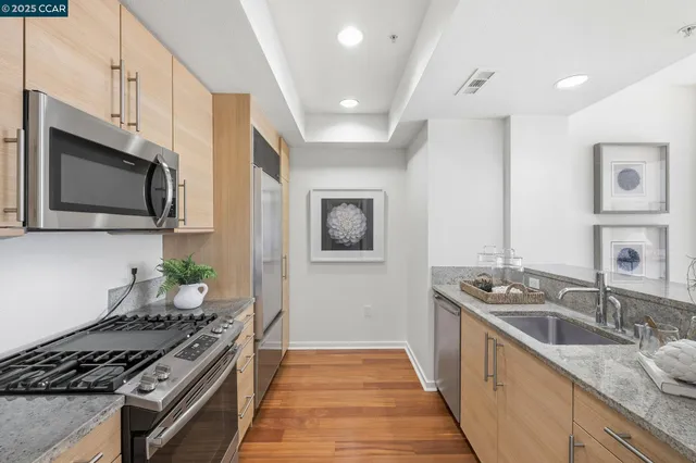 a kitchen with stainless steel appliances granite countertop a sink stove and microwave
