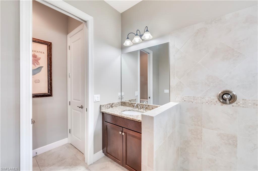 23778 Pebble Pointe Lane Estero, FL 34135 - Photo 24 of 35 a bathroom with a sink a mirror and a shower