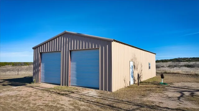 a kitchen with granite countertop wooden floors stainless steel appliances a sink and a window