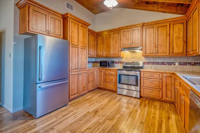 a view of empty room with wooden floor