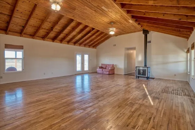 a view of an empty room with wooden floor and a fireplace