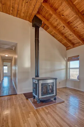 an empty room with wooden floor chandelier fan and windows