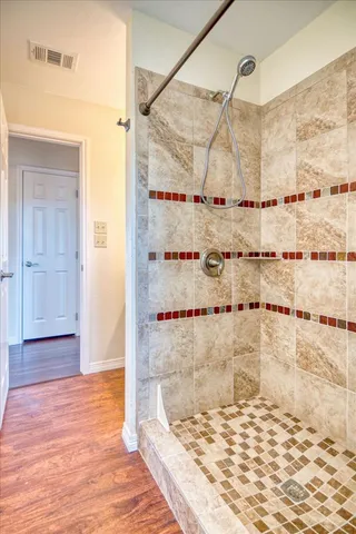 a bathroom with a sink a mirror and wooden floor
