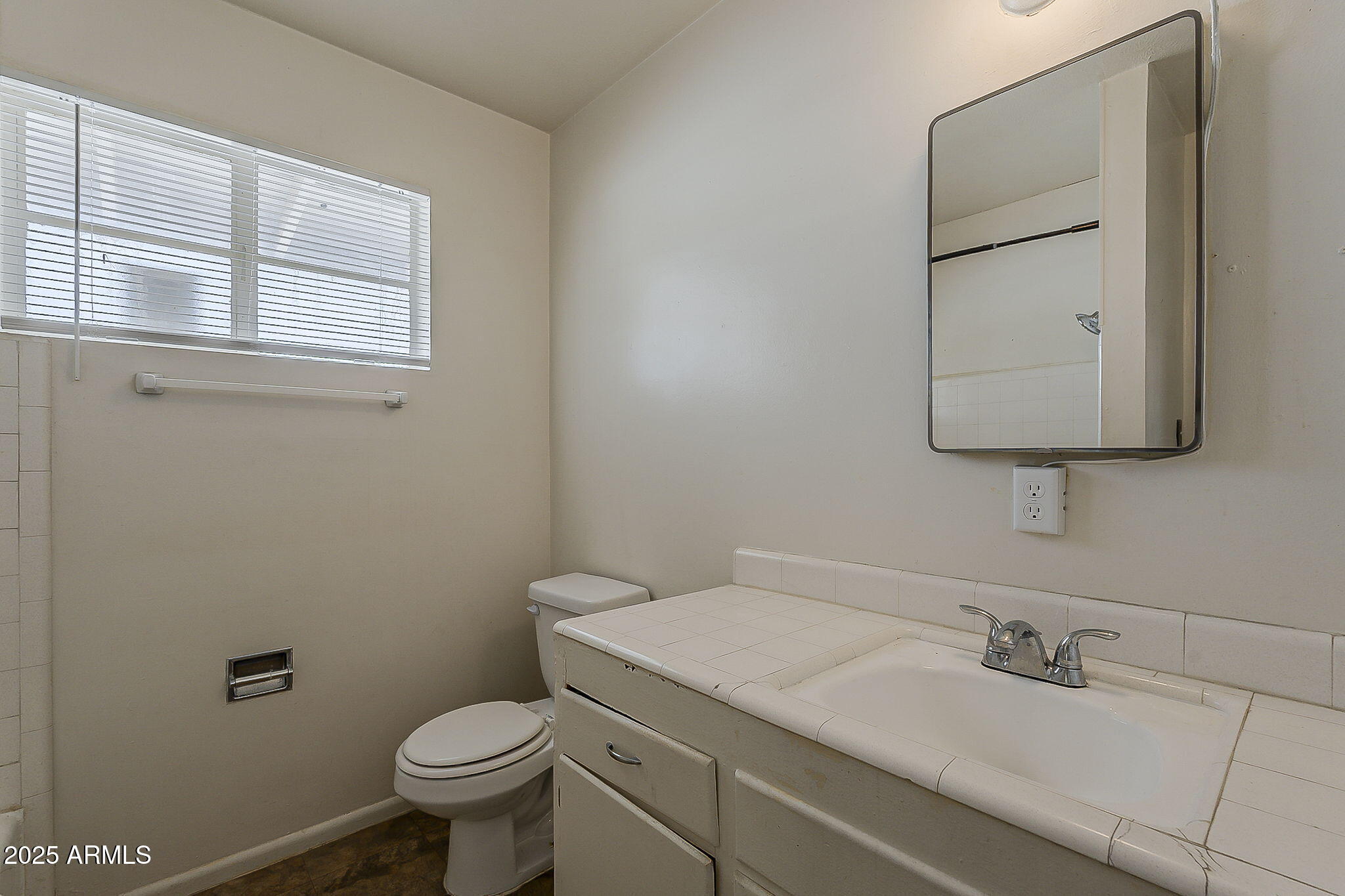 6225 North 10th Place Phoenix, AZ 85014 - Photo 19 of 32 a bathroom with a granite countertop toilet sink and mirror