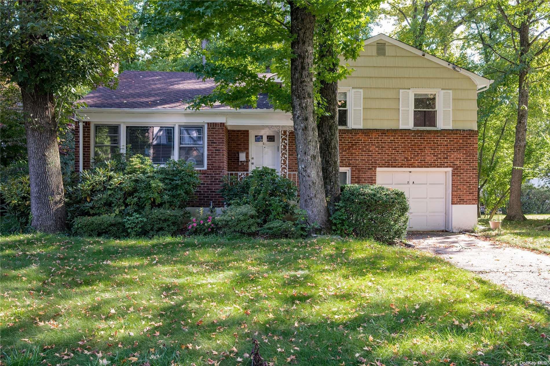 a front view of a house with a garden and yard