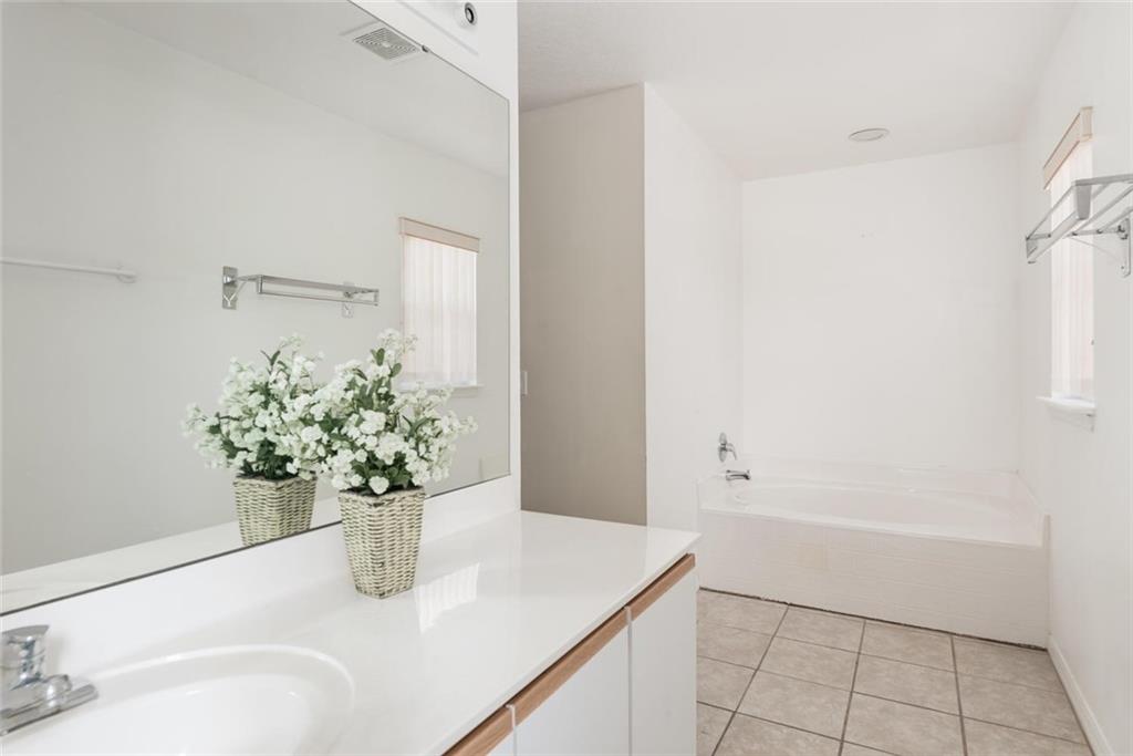 5665 Northwest Whitecap Road Port St. Lucie, FL 34986 - Photo 16 of 25 a bathroom with a granite countertop sink a vanity and a mirror