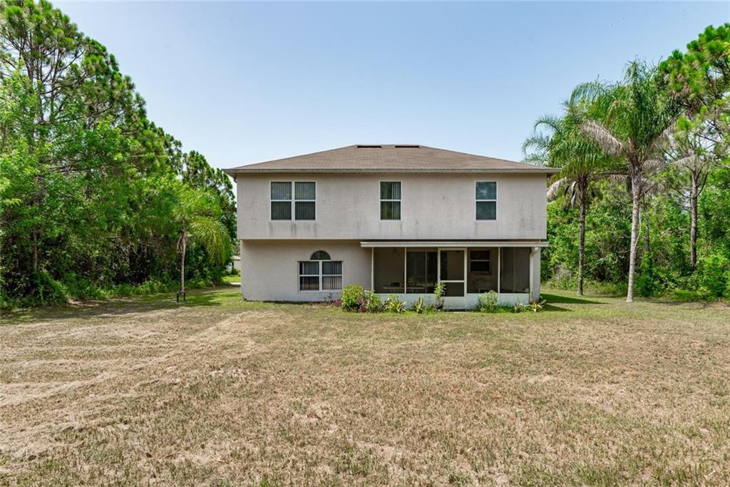5665 Northwest Whitecap Road Port St. Lucie, FL 34986 - Photo 23 of 25 a front view of a house with a yard
