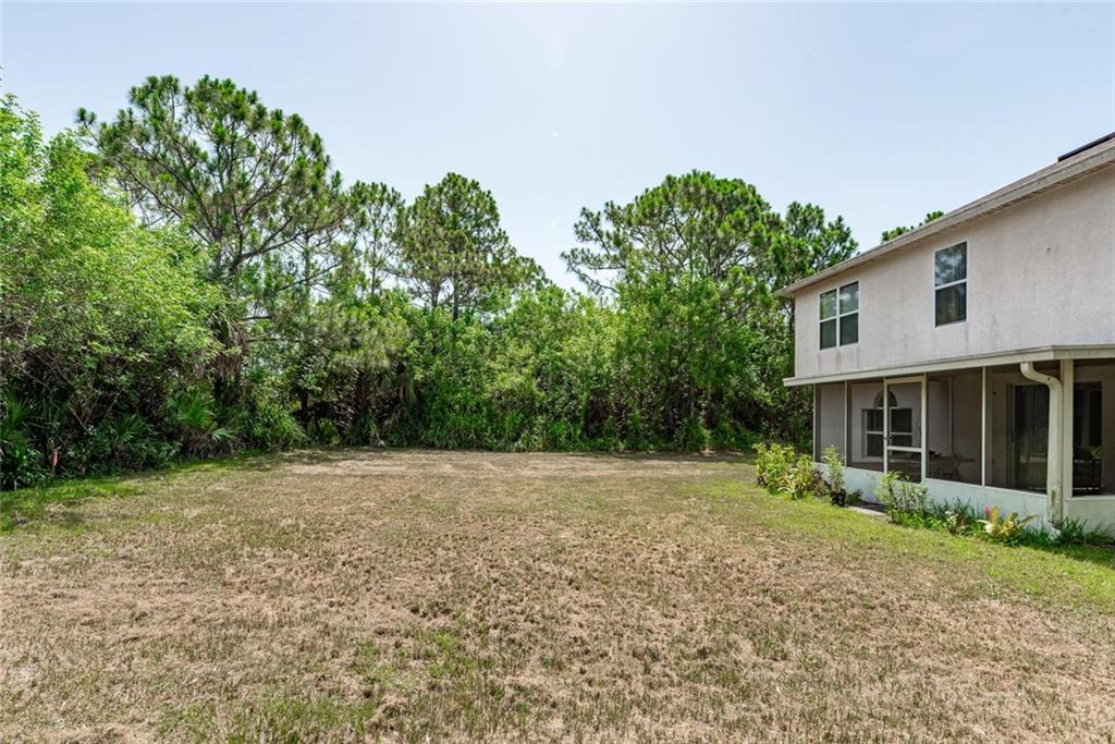 5665 Northwest Whitecap Road Port St. Lucie, FL 34986 - Photo 24 of 25 a view of backyard with plants and trees