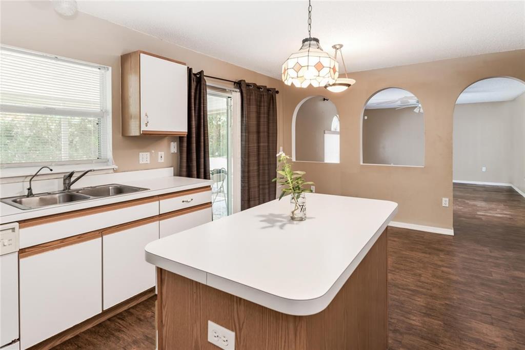 5665 Northwest Whitecap Road Port St. Lucie, FL 34986 - Photo 10 of 25 a kitchen with a sink a chandelier and wooden floor