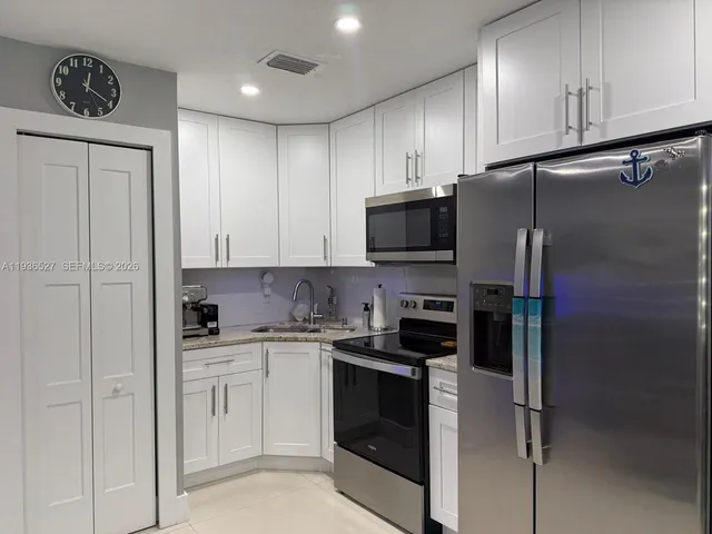 a kitchen with cabinets stainless steel appliances and sink