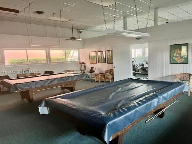 a kitchen with a stove a counter space and a view of living room