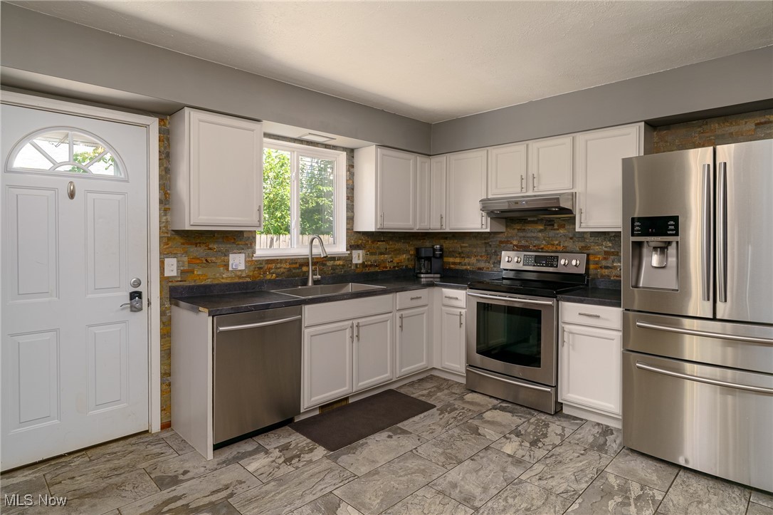 5497 Lear Nagle Road North Ridgeville, OH 44039 - Photo 15 of 33 Another view of kitchen with stainless appliances, white cabinets and ceramic flooring
