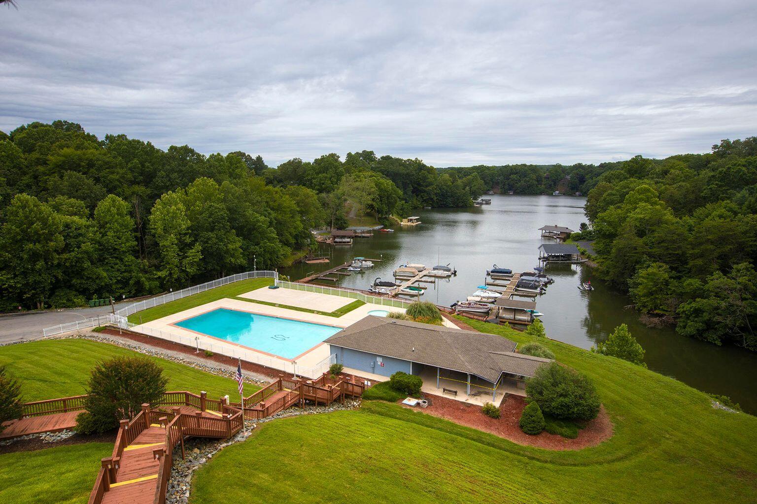 1089 Bluewater Drive, Unit 305 Moneta, VA 24121 - Photo 20 of 41 a view of a lake with lawn chairs and large trees