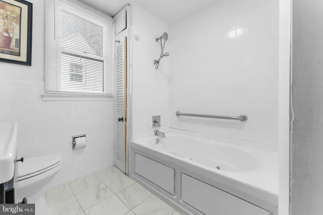 a bathroom with a bathtub a toilet and a shower