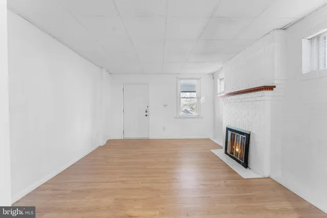 a view of empty room with wooden floor and fireplace