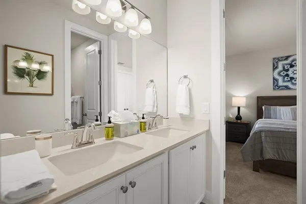 a en suite bathroom with a double vanity sink and a mirror
