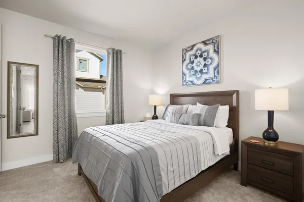 a bedroom with a bed and a lamp on table