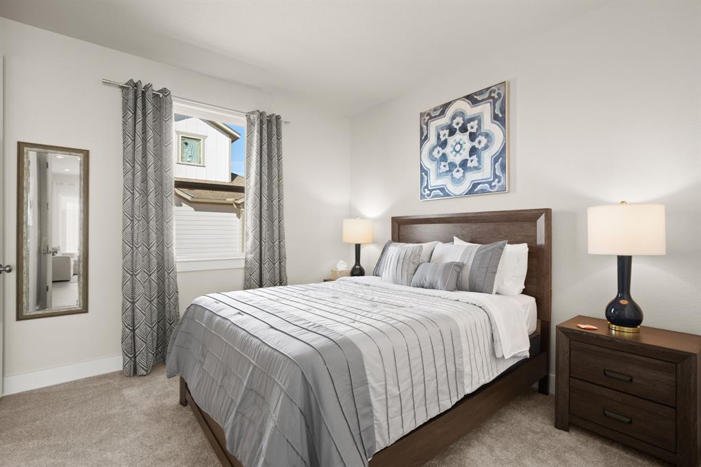 8810 Bestride Bend Austin, TX 78744 - Photo 27 of 35 a bedroom with a bed and a lamp on table