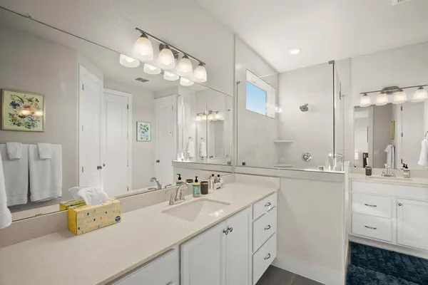 a spacious bathroom with a sink double vanity and a mirror