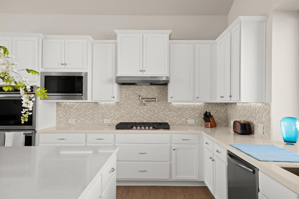 8810 Bestride Bend Austin, TX 78744 - Photo 8 of 35 a kitchen with white cabinets and white appliances