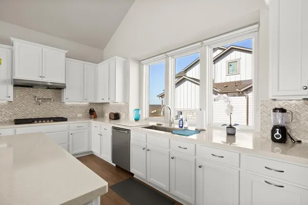 a kitchen with white cabinets and white appliances