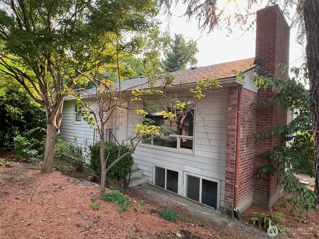 a front view of a house with plants and trees