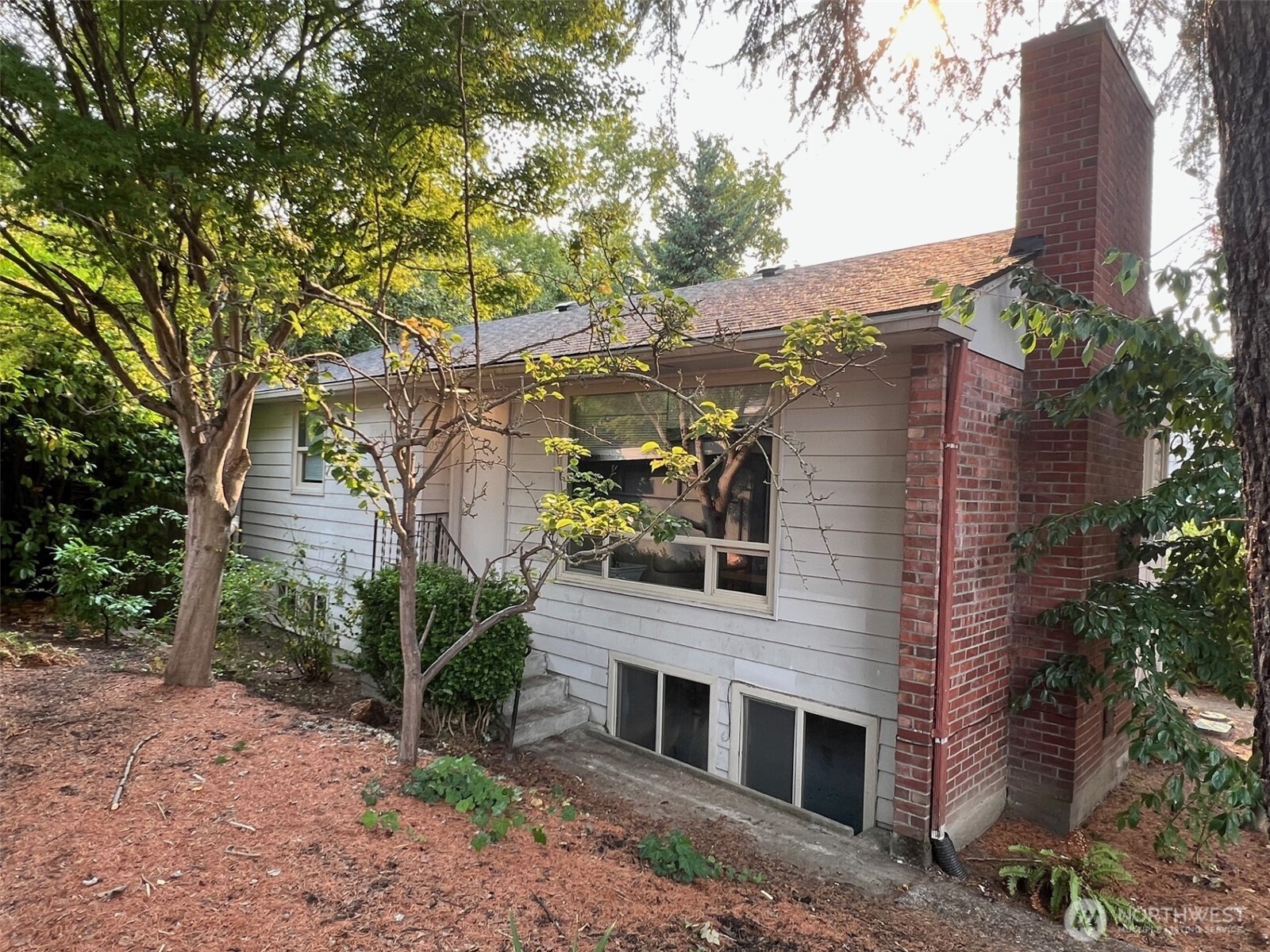 a front view of a house with plants and trees