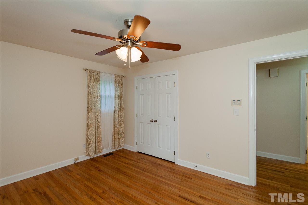 2313 Sheffield Road Raleigh, NC 27610 - Photo 16 of 25 an empty room with wooden floor fan and windows