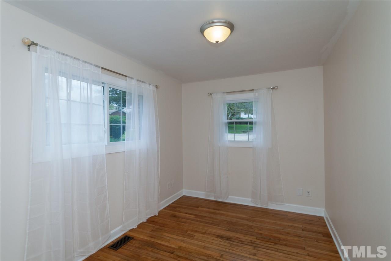 2313 Sheffield Road Raleigh, NC 27610 - Photo 18 of 25 an empty room with wooden floor and windows
