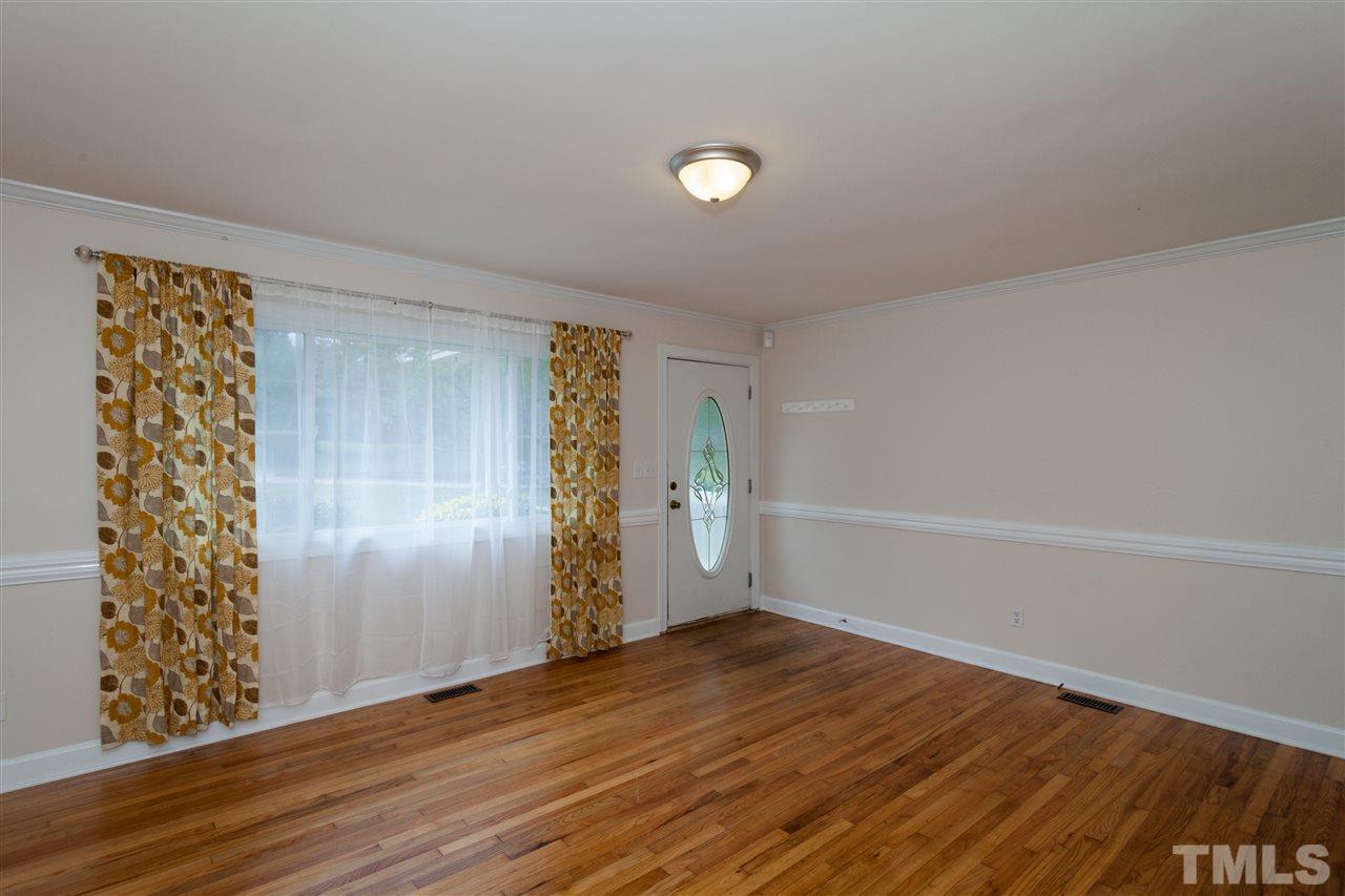 2313 Sheffield Road Raleigh, NC 27610 - Photo 7 of 25 a view of an empty room with wooden floor and entryway
