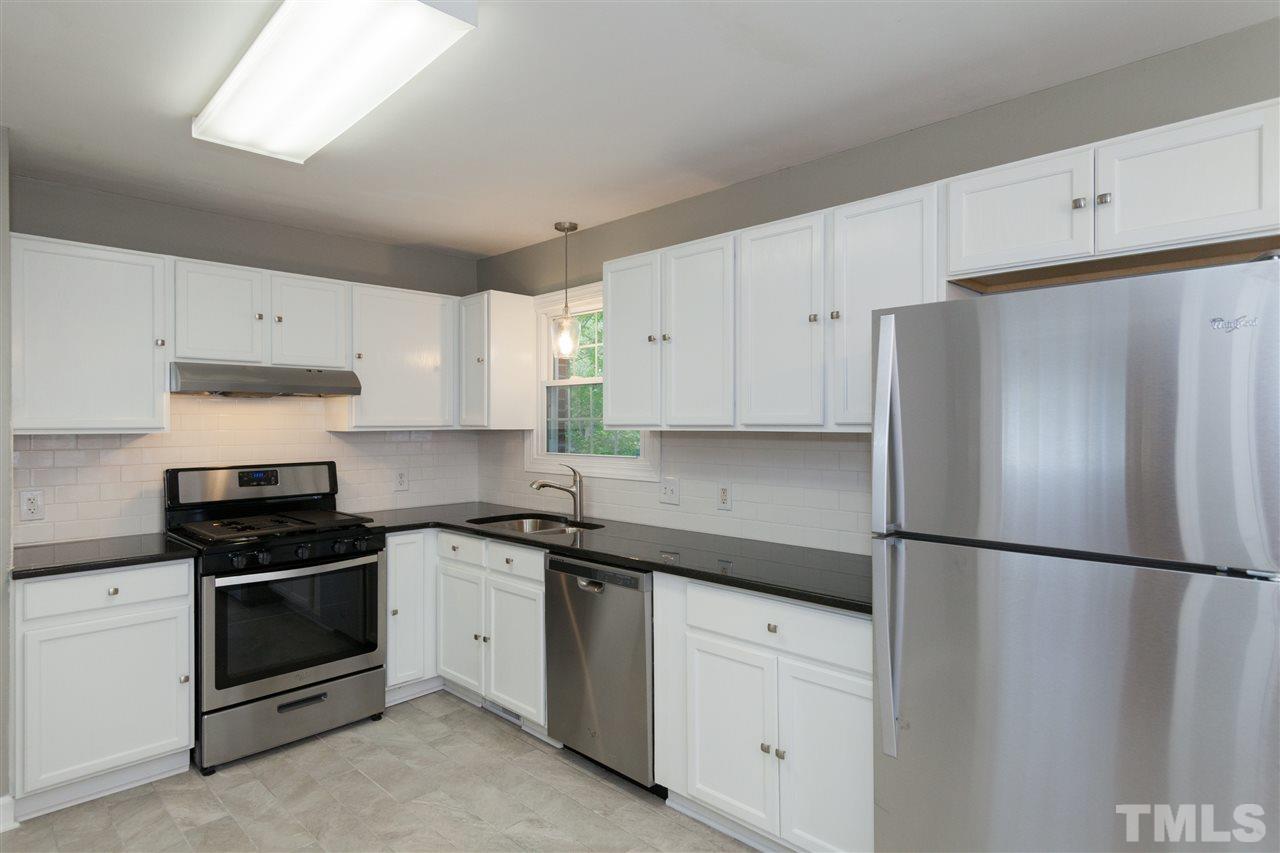 2313 Sheffield Road Raleigh, NC 27610 - Photo 9 of 25 a kitchen with cabinets and stainless steel appliances