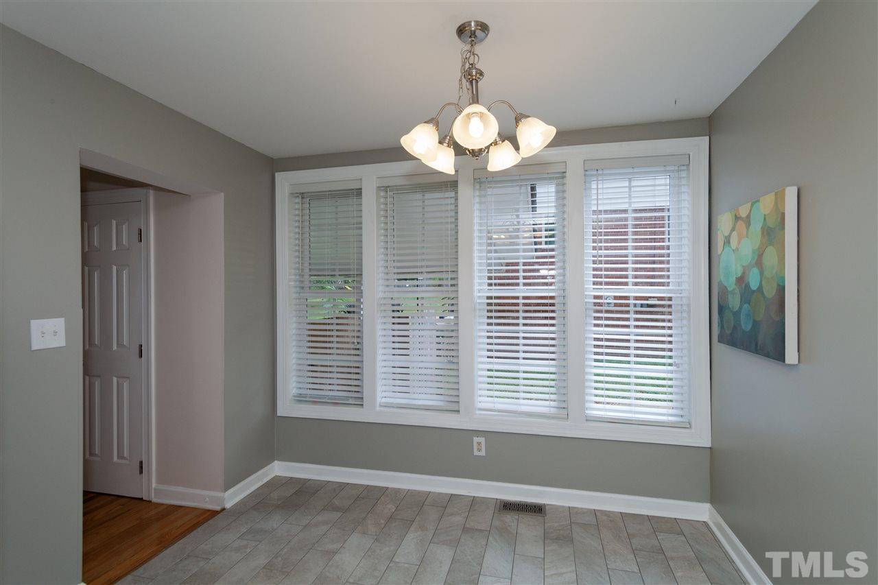 2313 Sheffield Road Raleigh, NC 27610 - Photo 10 of 25 a view of a room with a large window ceiling fan and wooden floor